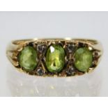 A 9ct gold ring with diamond & peridot on carved s