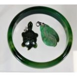 A jade carved pendant twinned with similar hardsto