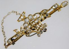 A yellow metal brooch, tests as 20ct gold, decorated with lyre set with fine white diamonds of super