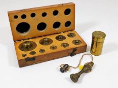 A cased set of gold weights, a brass lens case & a
