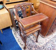 A mahogany childs high chair with carved decor