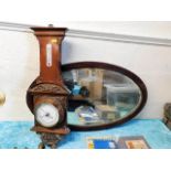 An oval mirror twinned with a barometer