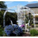 A decorative arbour with a garden table with four