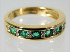 An 18ct gold emerald & diamond half eternity ring