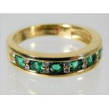 An 18ct gold emerald & diamond half eternity ring