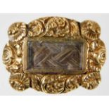A 19thC. yellow metal memorial brooch with carved