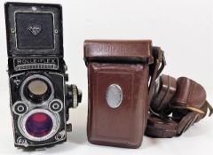 A cased Rolleiflex camera with accessories