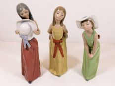 Three Lladro figures of ladies, tallest 9.25in high, one with loss to bow on cap