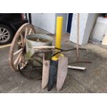 A wagon wheel twinned with a two handled saw & far