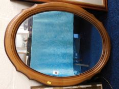 An oval wooden framed mirror