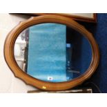 An oval wooden framed mirror