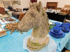 A weathered garden concrete bust of horse head