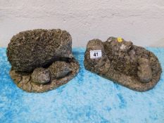 Two weathered concrete garden hedgehogs