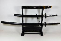 A rack of three very sharp Japanese swords includi