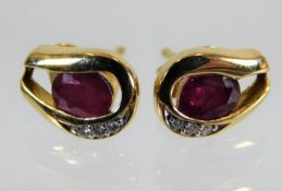 A pair of 18ct gold earrings set with ruby & diamo