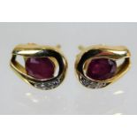 A pair of 18ct gold earrings set with ruby & diamo