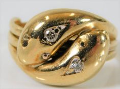 A 19thC. yellow metal double snake ring, tests as