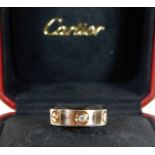 An 18ct rose gold Cartier Love ring set with three