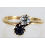 An 18ct gold crossover ring set with sapphire & o.