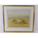 A framed watercolour depicting haystacks within su