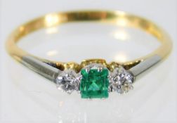 An 18ct gold ring set with diamond & emerald on a