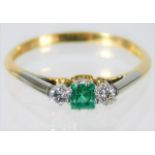 An 18ct gold ring set with diamond & emerald on a