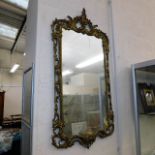 A wall mirror fitted with a decorative brass frame