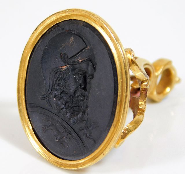An 18thC. yellow metal seal, tests as high carat gold, with crest in basalt