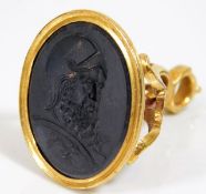 An 18thC. yellow metal seal, tests as high carat gold, with crest in basalt