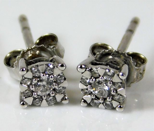 A pair of 9ct white gold earrings each set with ni