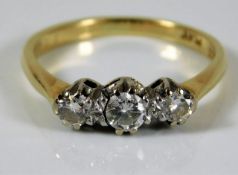 An 18ct gold trilogy ring with platinum mounted di