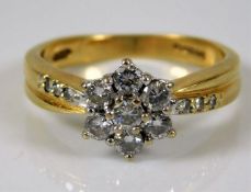 An 18ct gold ring with a floral arrangement of sev
