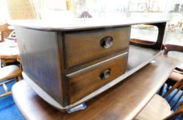 An Ercol elm low level table with drawers