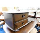 An Ercol elm low level table with drawers