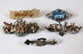 A selection of white & yellow metal brooches