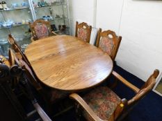 An oak table with six upholstered oak chairs including two carvers