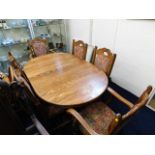 An oak table with six upholstered oak chairs including two carvers