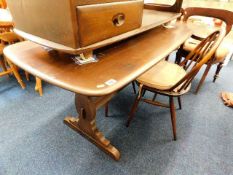 An Ercol elm dining table with two chairs