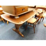 An Ercol elm dining table with two chairs