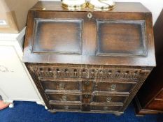 An oak bureau with brass fittings