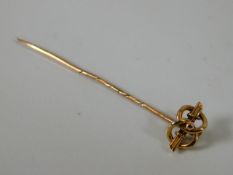 A yellow metal tie pin with knot design 1.4g