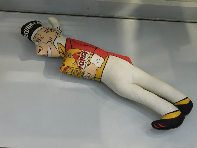 A Sunny Jim stuffed figure with Force Wheat Flakes