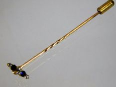 A yellow metal tie pin set with white & blue stone