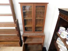 A teak bookcase with shelves under