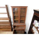 A teak bookcase with shelves under