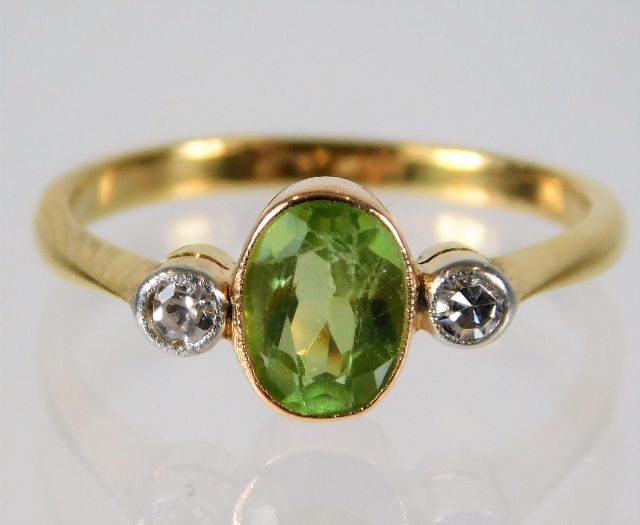 An 18ct gold ring set with peridot & 0.1ct diamond