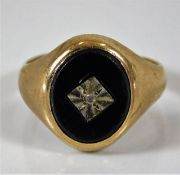 A 9ct gold signet ring set with onyx & white stone