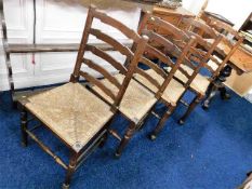 A set of four antique ladder back rush seat chairs