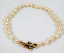 A pearl bracelet set with yellow metal clasp, test