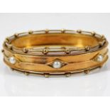 A Victorian yellow metal bangle set with pearl 21.5g tests 14ct gold